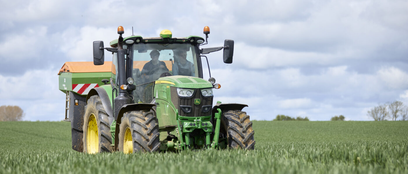 Two students driving a tractor in a field