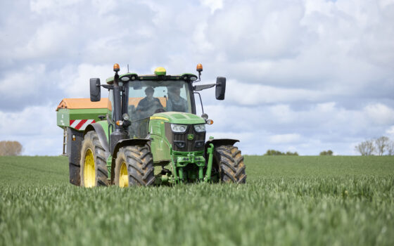 Two students driving a tractor in a field