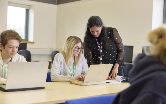 teacher showing student things on laptop