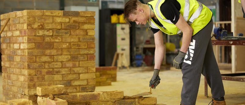 bricklaying student laying mortar.