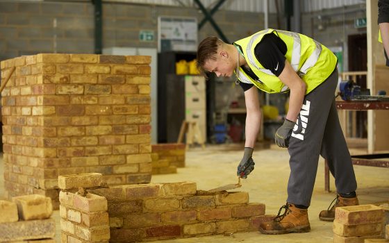 bricklaying student laying mortar.