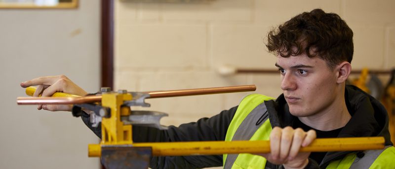 Plumbing student working on pipes