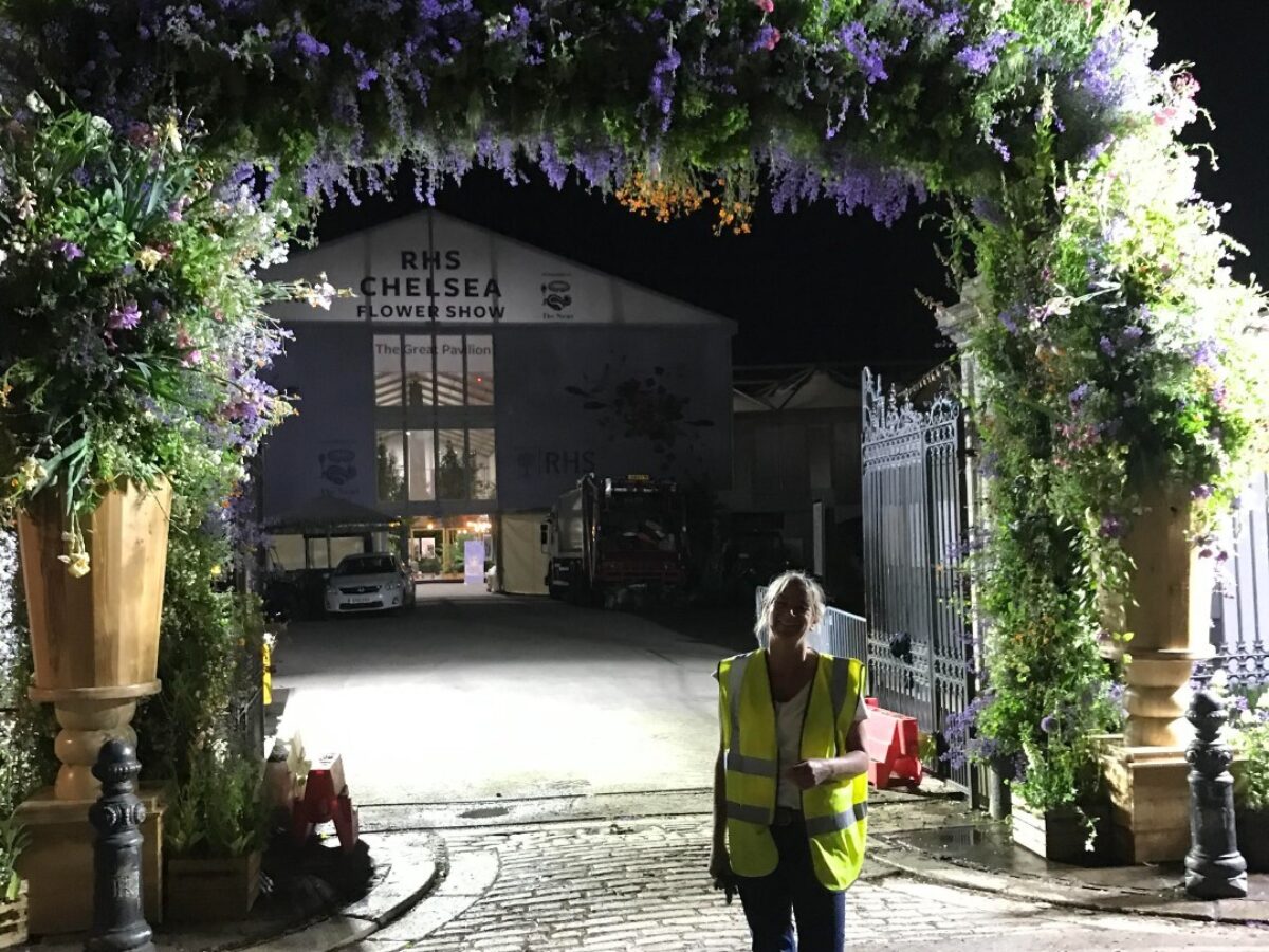 Alison underneath the floral archway entrance she helped create