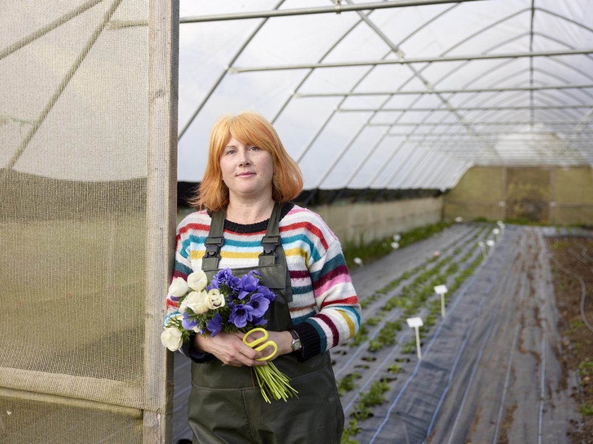 Floristry student Rebecca standing in the doorway of a polytunnel at her work experience placement