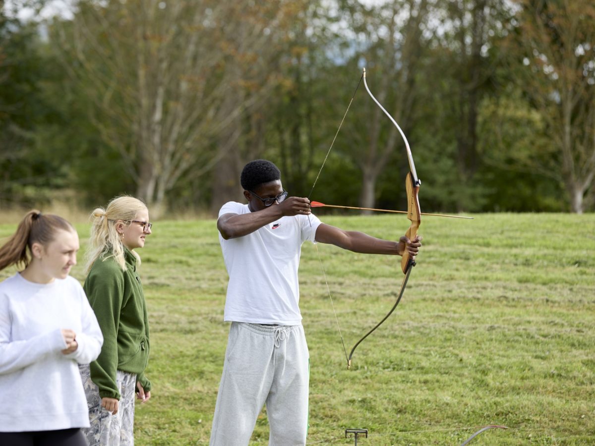 Student aiming bow an arrow at Caldecotte Xperience trip