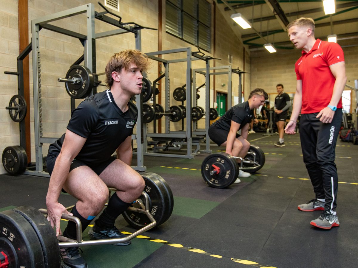 Student weightlifting in gym