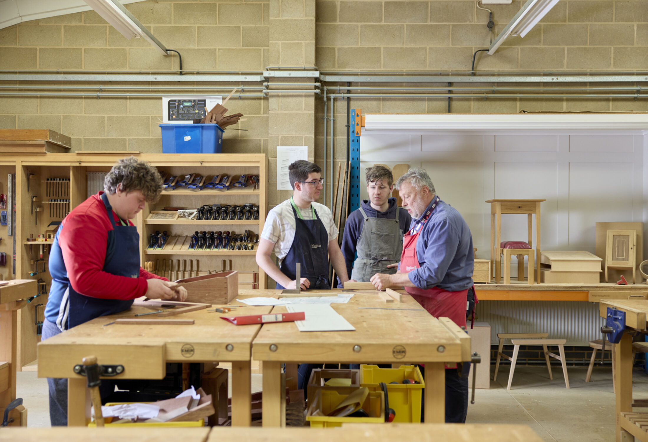 Furniture students and member of staff working together within furniture workshop