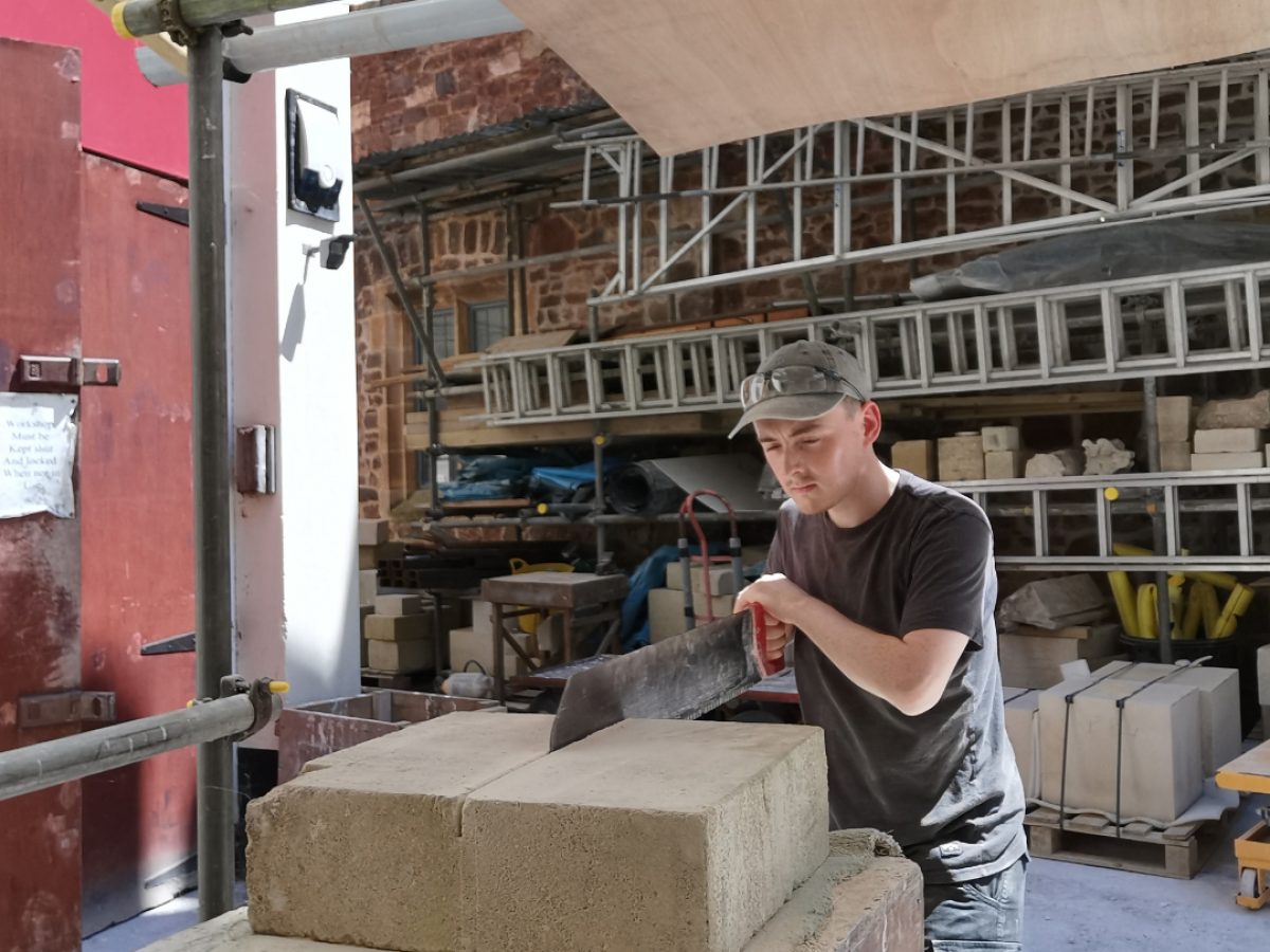 John cutting block of stone