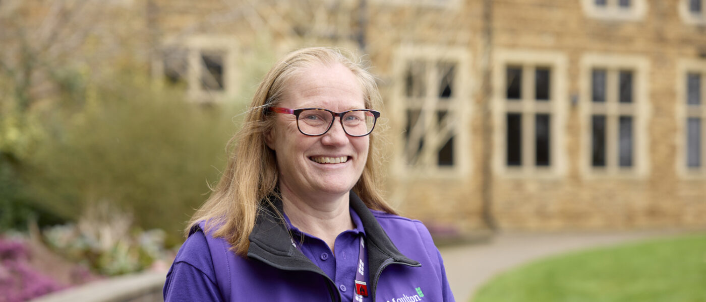 Careers Advisor smiling wearing a purple moulton polo and vest
