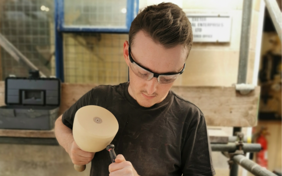 John chiseling block of stone